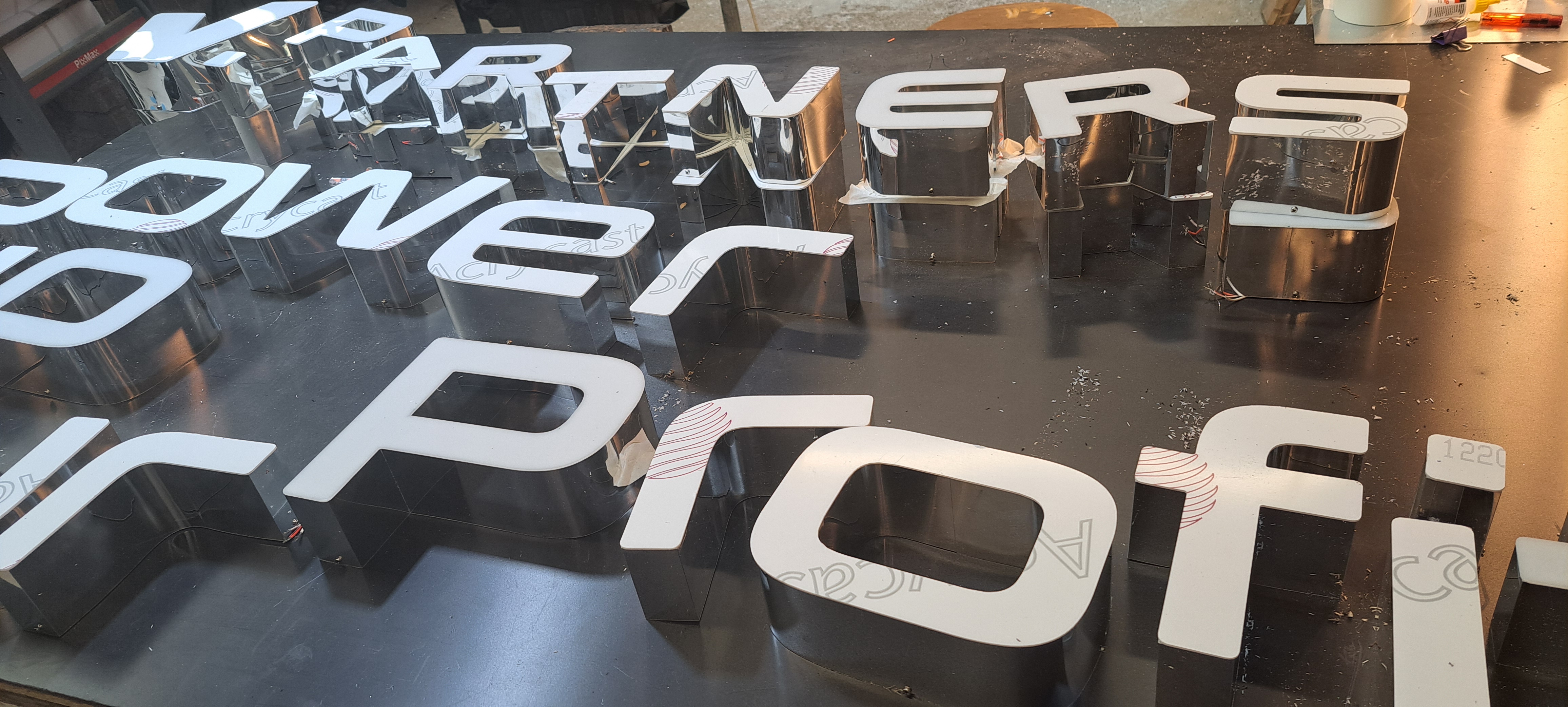 Stainless steel face-lit channel letters for Power up your profit laid out during fabrication.